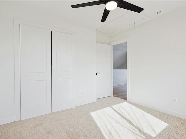 unfurnished bedroom featuring ceiling fan, light colored carpet, and a closet