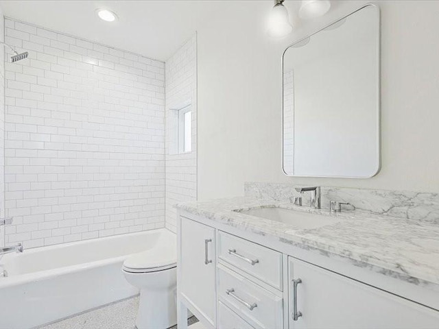 full bathroom featuring tiled shower / bath, vanity, and toilet