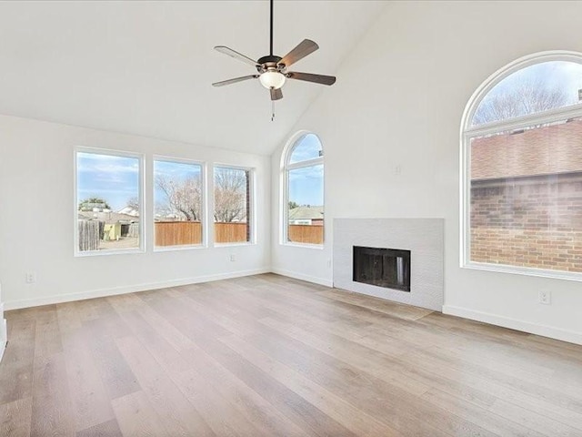 unfurnished living room with ceiling fan, high vaulted ceiling, and light hardwood / wood-style floors