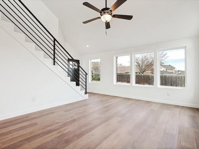 unfurnished living room with high vaulted ceiling, ceiling fan, and light wood-type flooring