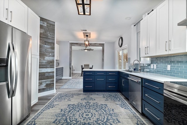 kitchen with stainless steel appliances, blue cabinets, sink, and white cabinets