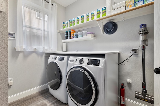 laundry room featuring washing machine and dryer and light hardwood / wood-style flooring