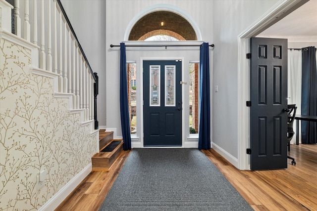 entrance foyer featuring hardwood / wood-style flooring and a towering ceiling