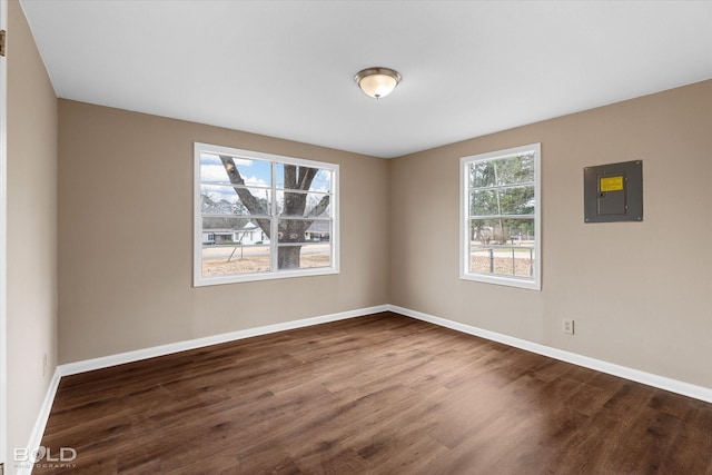 spare room featuring dark hardwood / wood-style floors and electric panel