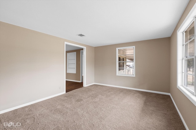 spare room with dark carpet