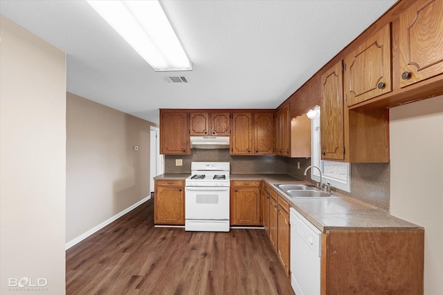 kitchen featuring tasteful backsplash, white appliances, dark hardwood / wood-style flooring, and sink