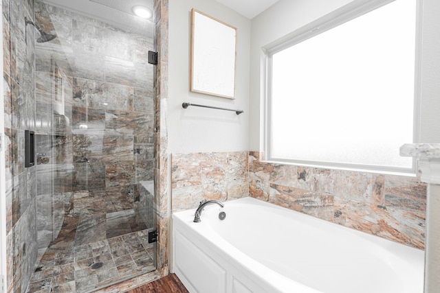 bathroom featuring plus walk in shower and a wealth of natural light