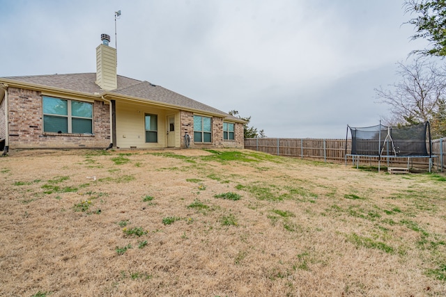 rear view of property featuring a trampoline