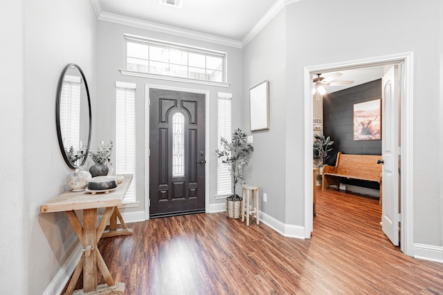 foyer with ornamental molding and dark hardwood / wood-style floors