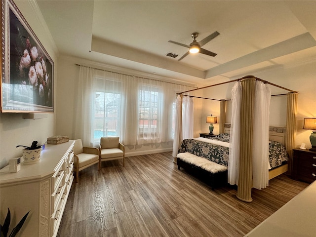 bedroom featuring wood-type flooring, ceiling fan, and a tray ceiling