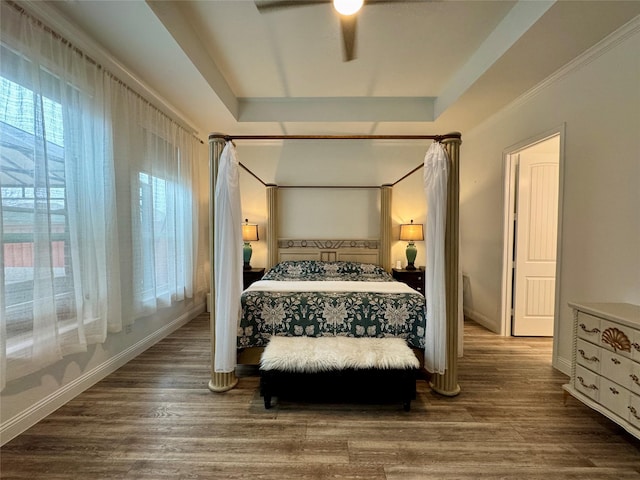 bedroom featuring ceiling fan, wood-type flooring, and a raised ceiling