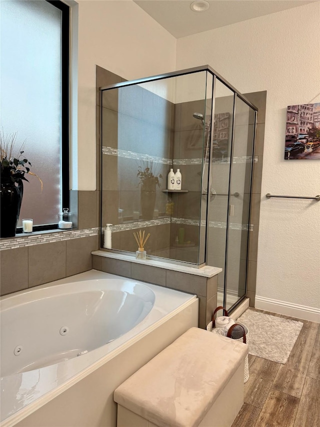 bathroom featuring plus walk in shower and hardwood / wood-style floors