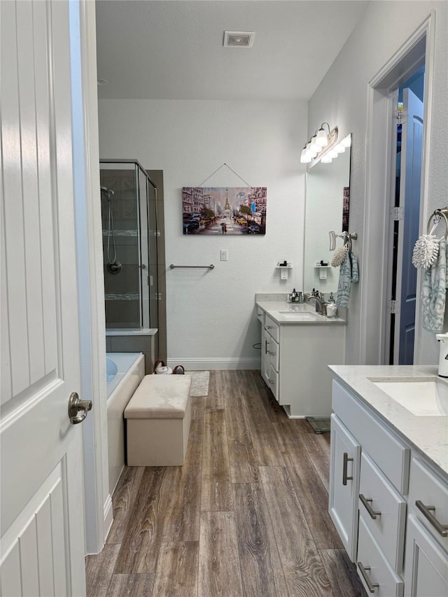 bathroom featuring vanity, hardwood / wood-style floors, and separate shower and tub