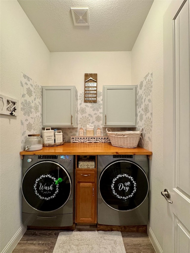 laundry room featuring dark hardwood / wood-style floors, cabinets, and a textured ceiling