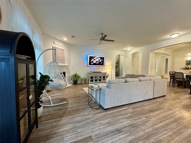 living room featuring wood-type flooring and ceiling fan