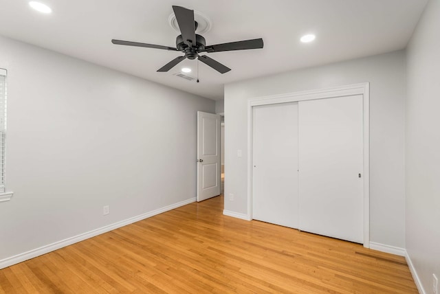 unfurnished bedroom with ceiling fan, a closet, and light wood-type flooring