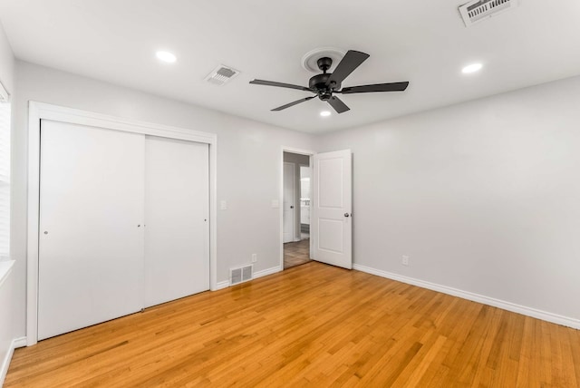 unfurnished bedroom featuring ceiling fan, a closet, and light hardwood / wood-style flooring