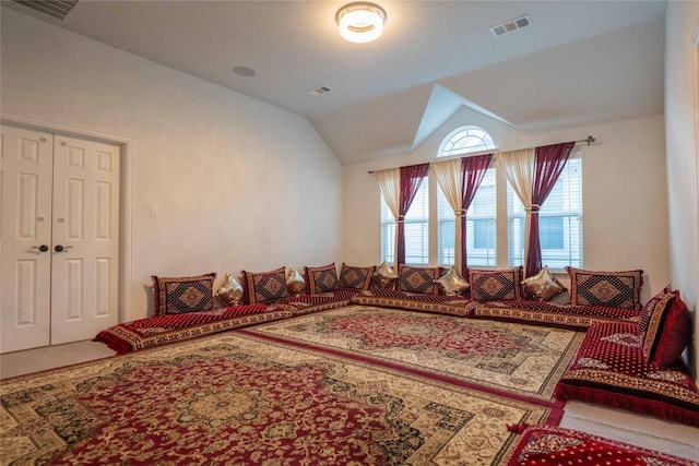 living area featuring lofted ceiling, carpet floors, and visible vents