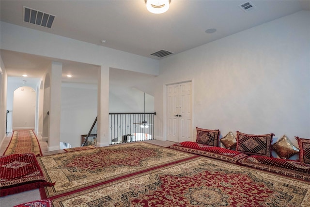 bedroom with baseboards, visible vents, and arched walkways