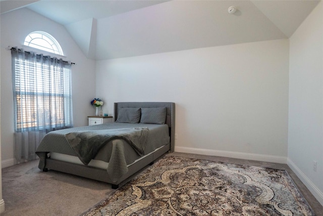 carpeted bedroom with vaulted ceiling and baseboards