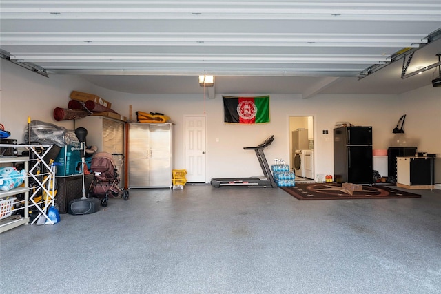 garage with a garage door opener, separate washer and dryer, and freestanding refrigerator