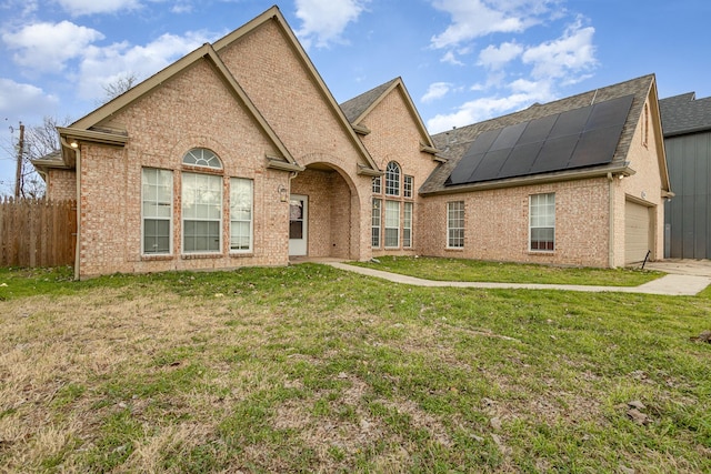 view of front of house with a garage, a front lawn, and solar panels