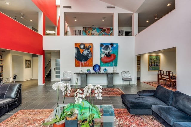 living room with tile patterned flooring and a towering ceiling