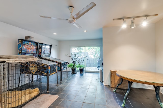 recreation room with ceiling fan, rail lighting, and dark tile patterned floors