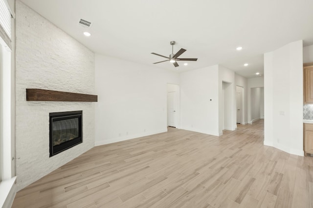 unfurnished living room with recessed lighting, a fireplace, visible vents, and light wood-style floors