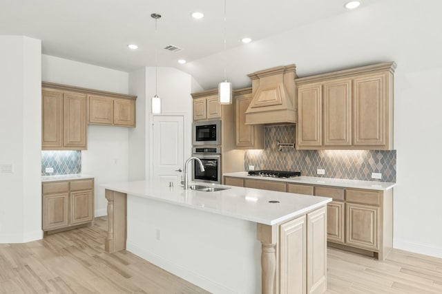 kitchen featuring premium range hood, appliances with stainless steel finishes, light countertops, and a sink