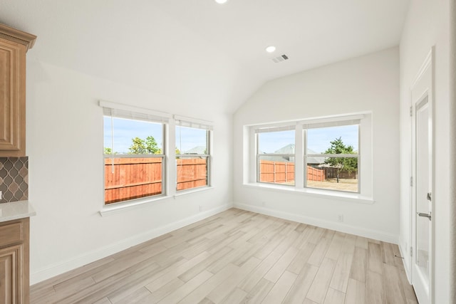 interior space featuring visible vents, baseboards, light wood-style flooring, vaulted ceiling, and recessed lighting