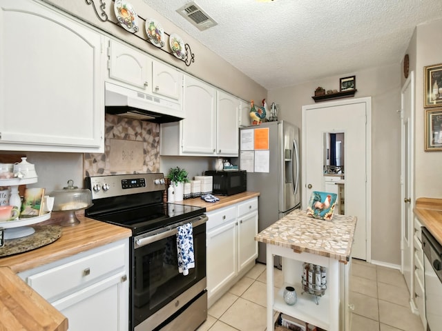 kitchen with appliances with stainless steel finishes, wood counters, visible vents, and under cabinet range hood