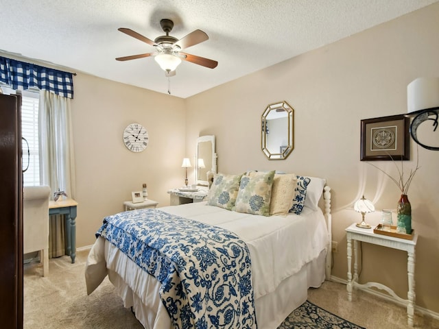 carpeted bedroom featuring ceiling fan, a textured ceiling, and baseboards