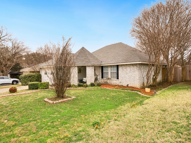 single story home with an attached garage, brick siding, fence, and a front yard