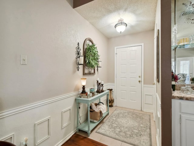 entryway featuring tile patterned floors and a textured ceiling