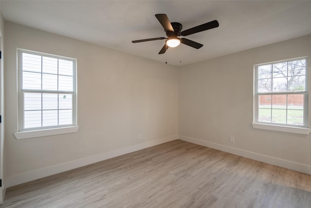 spare room with ceiling fan, plenty of natural light, and light hardwood / wood-style floors