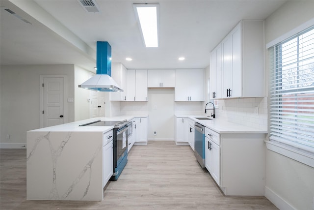 kitchen featuring light stone counters, stainless steel appliances, white cabinets, and island exhaust hood