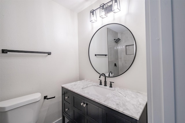 bathroom with vanity, toilet, and a shower