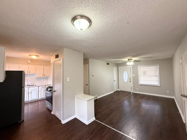 entrance foyer with dark wood-type flooring, ceiling fan, sink, and a textured ceiling