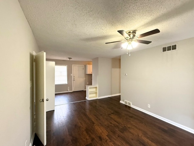 spare room with a textured ceiling, dark hardwood / wood-style floors, and ceiling fan