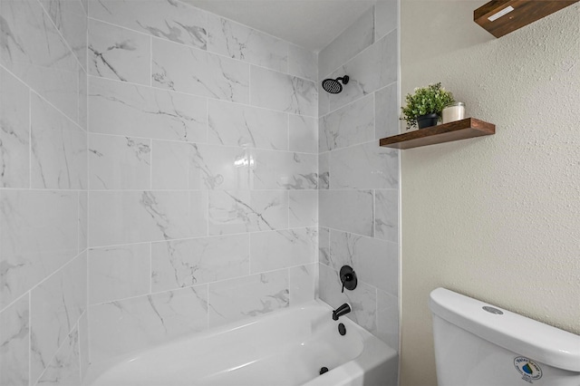 bathroom with toilet and tiled shower / bath