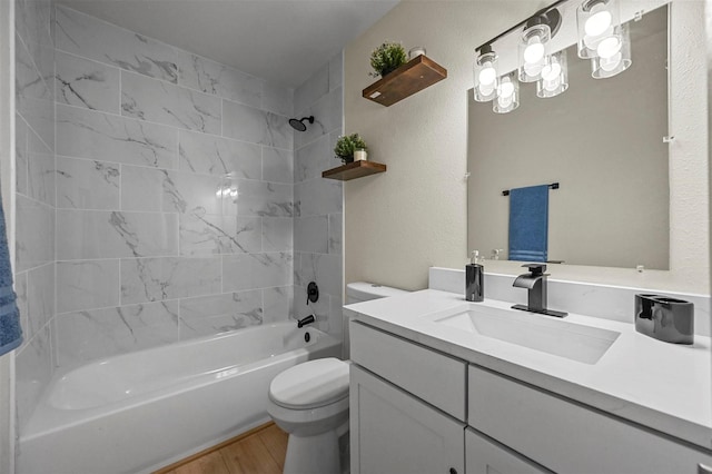 full bathroom with vanity, tiled shower / bath combo, toilet, and hardwood / wood-style flooring