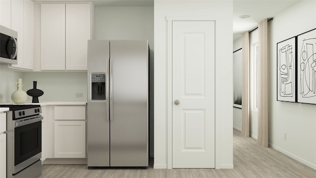 kitchen with white cabinetry, light hardwood / wood-style floors, and appliances with stainless steel finishes