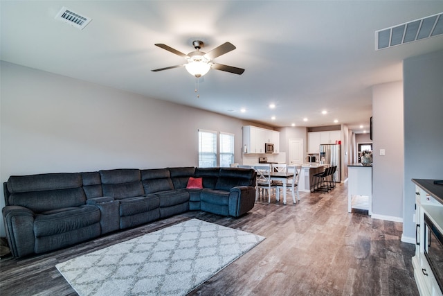 living room featuring hardwood / wood-style flooring and ceiling fan