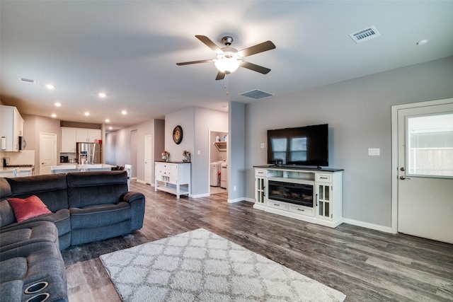 living room with ceiling fan and dark hardwood / wood-style flooring