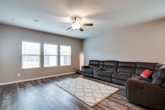 living room with dark wood-type flooring and ceiling fan