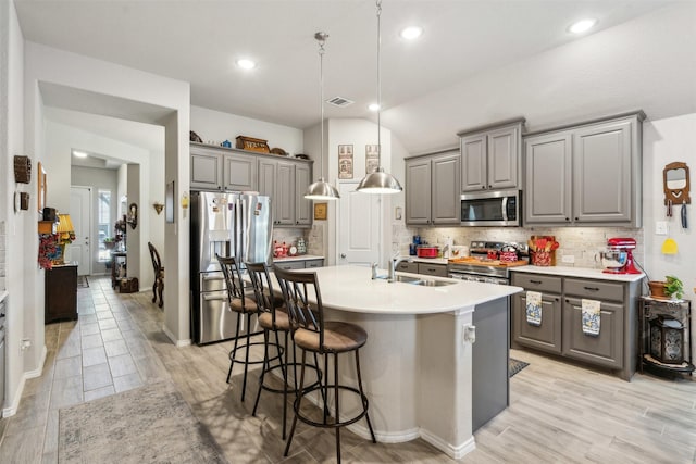 kitchen with a sink, stainless steel appliances, gray cabinetry, and visible vents