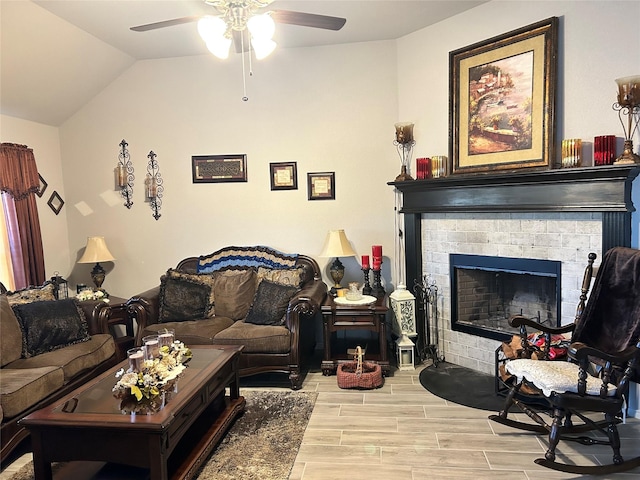 living room with wood finish floors, ceiling fan, a fireplace, and vaulted ceiling