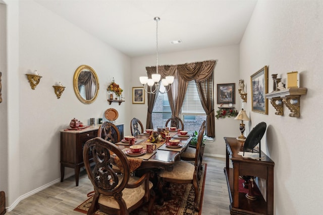 dining room featuring a chandelier, visible vents, light wood-type flooring, and baseboards