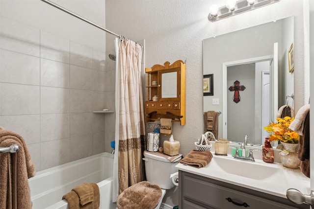 bathroom with shower / tub combo with curtain, toilet, vanity, and a textured wall